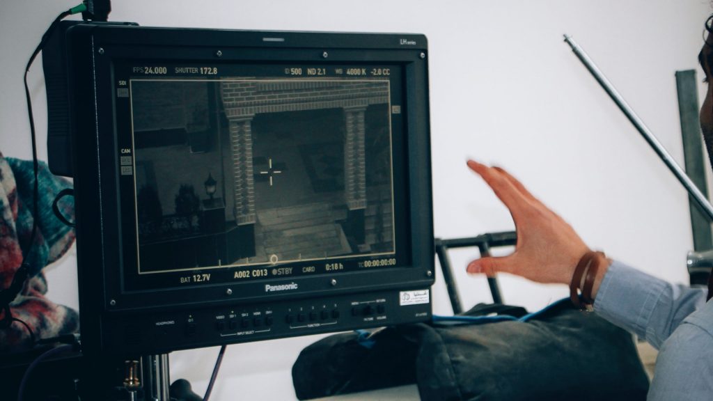 Hand beside filming screen monitor