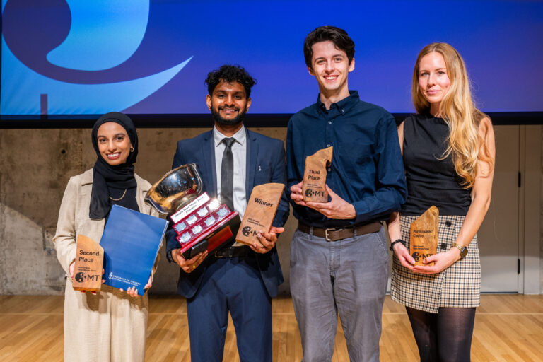 The four winners of the Ontario Three Minute Thesis stand in front of a large blue screen, holding their trophies.